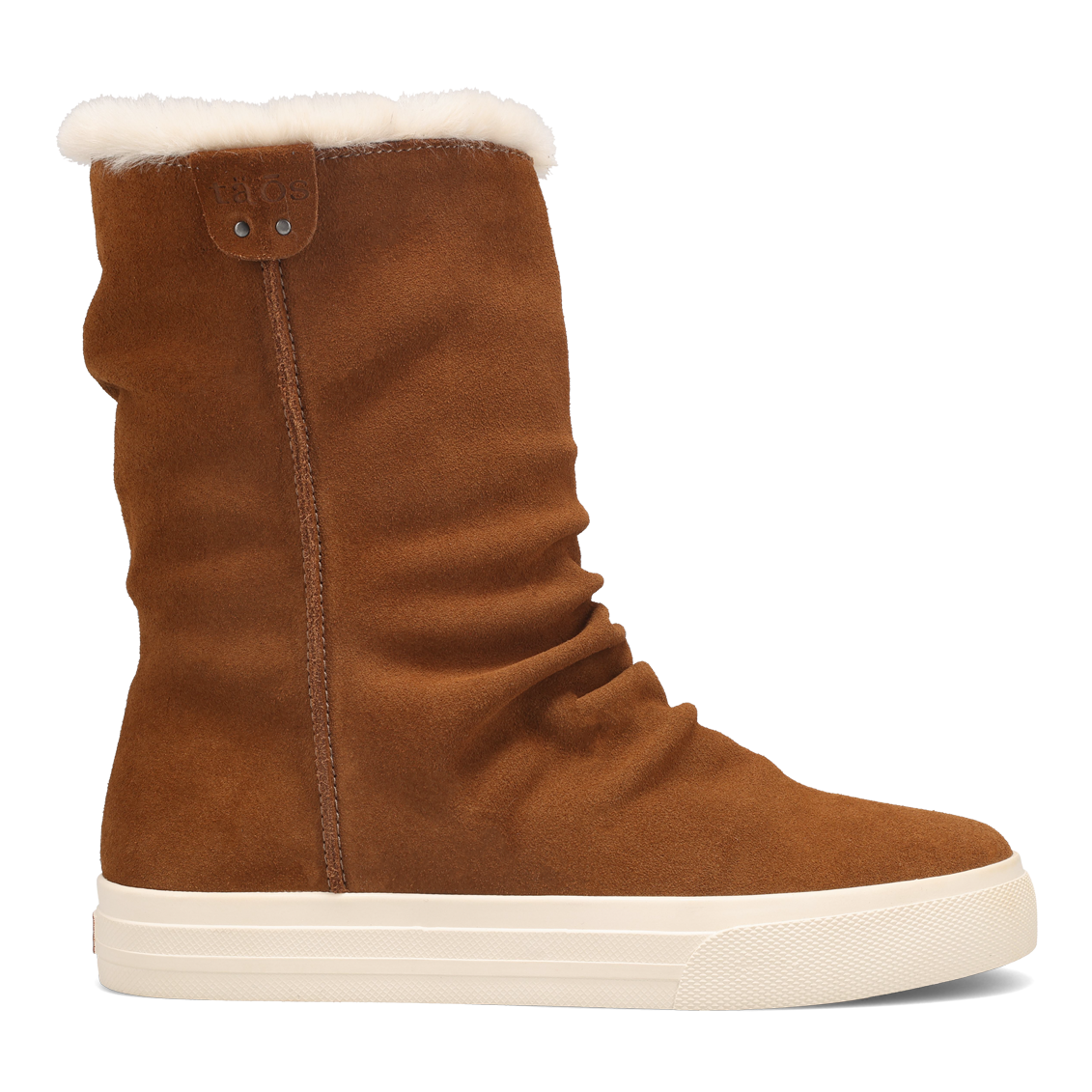 Brown Taos Cozy Chic Boots with a slouchy suede upper and a white, flat sole. The interior is lined with plush, warm material, and there’s a small leather brand tag near the top.
