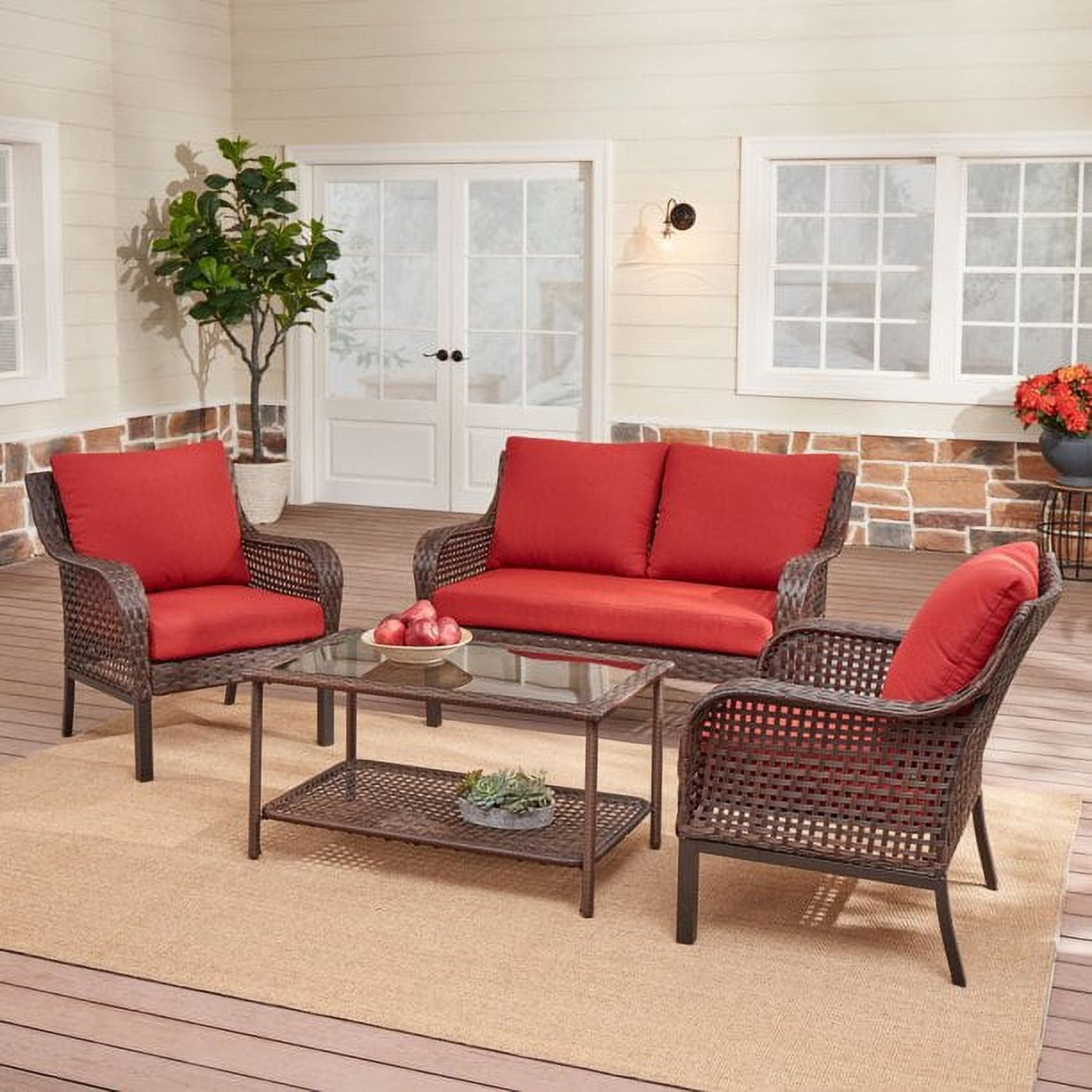 Outdoor patio furniture set with red cushions, including a sofa, two chairs, and a glass-top coffee table.