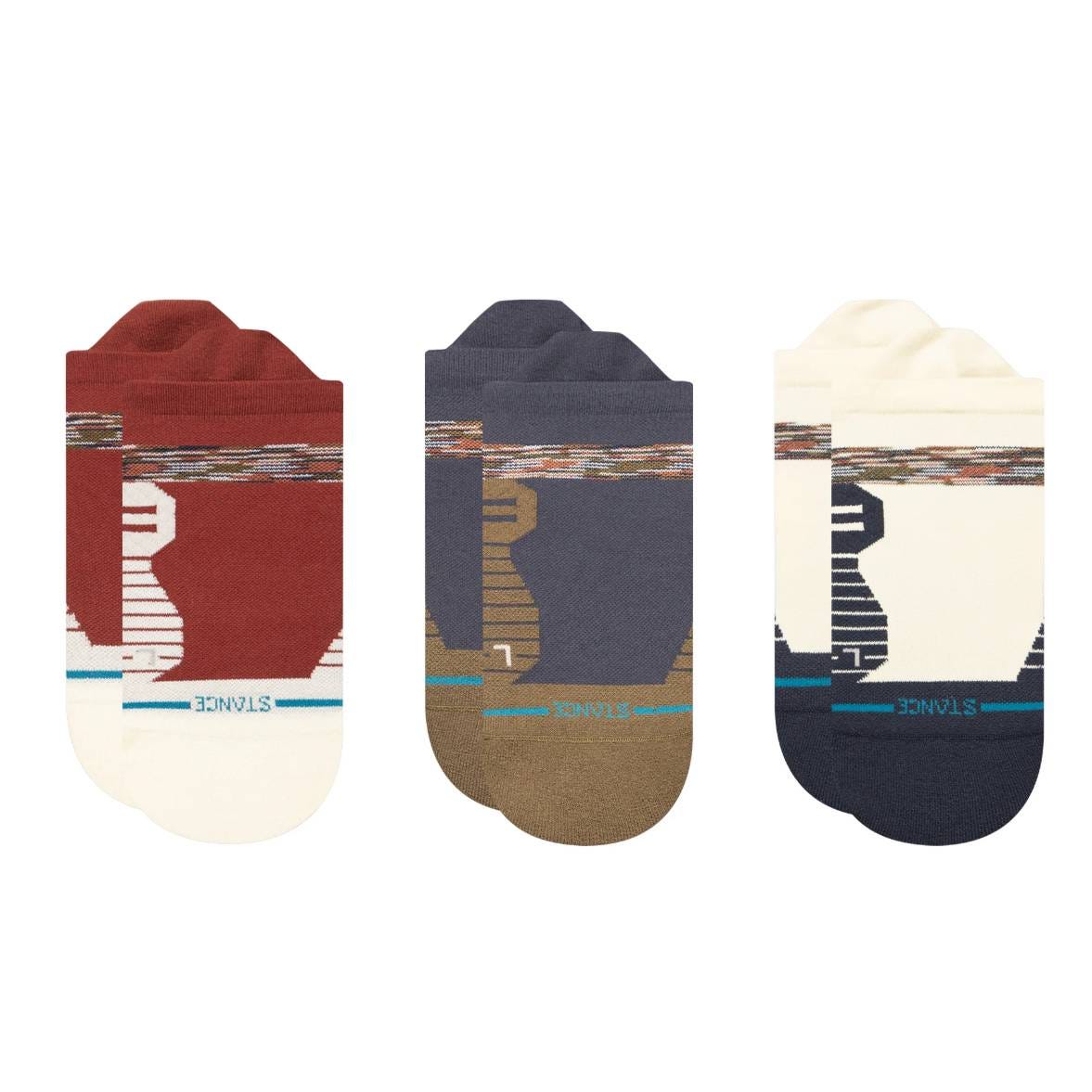 Three pairs of Stance performance socks featuring abstract patterns are shown. The colors include a red and white pair, a navy and brown pair, and a cream and navy pair.