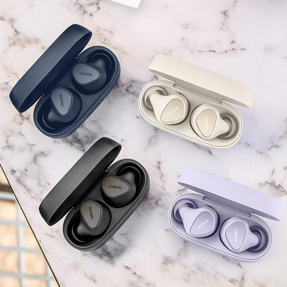 Four pairs of Jabra wireless earbuds in open cases, shown in different colors: dark blue, light beige, black, and light purple.