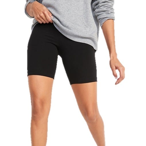 A person wearing black biker shorts paired with a gray sweatshirt.