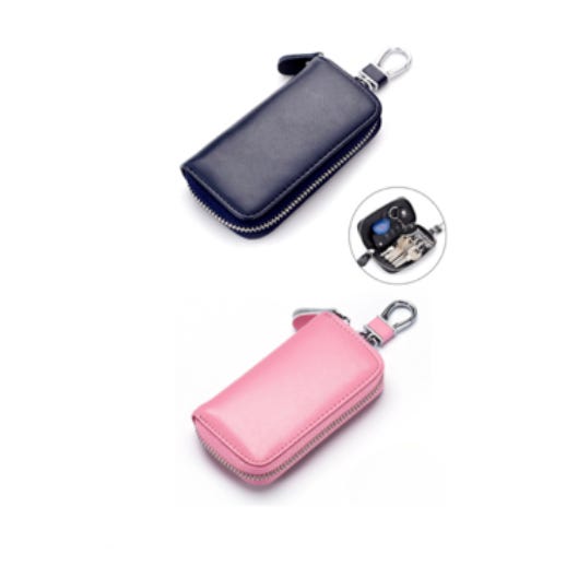 Two leather key pouches with zippers, one in navy blue and one in pink, with a car key and fob inside the blue one, indicating they're used for holding keys.