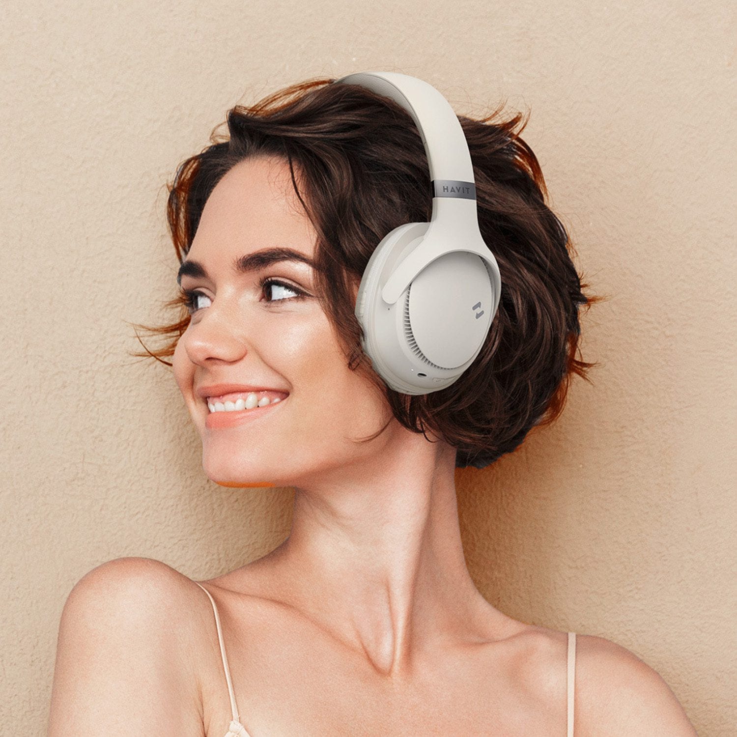 A smiling person wearing over-ear headphones.