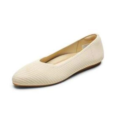A cream-colored, flat shoe with a textured surface and a low-profile, rounded toe design.