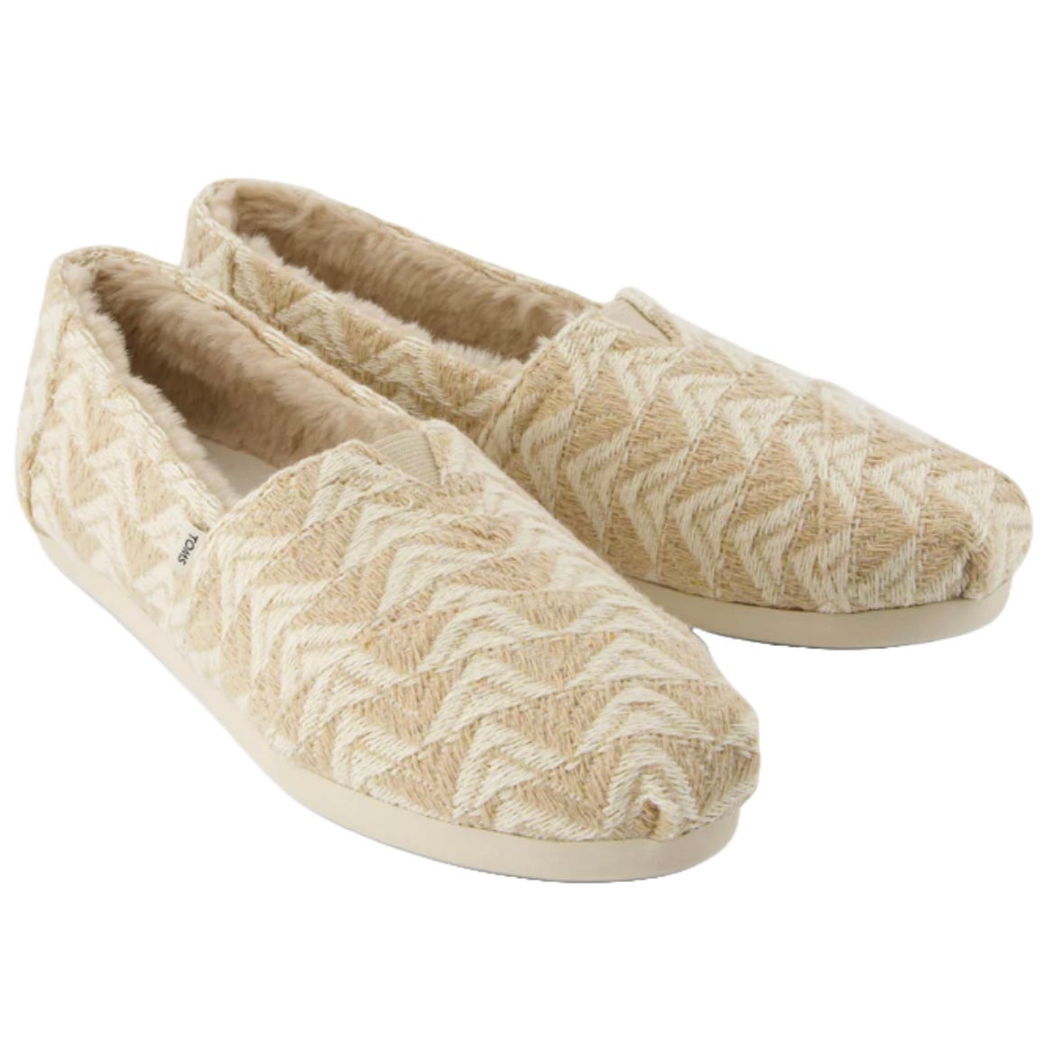 Beige slip-on shoes with a furry lining and a zigzag pattern, featuring a flat sole.