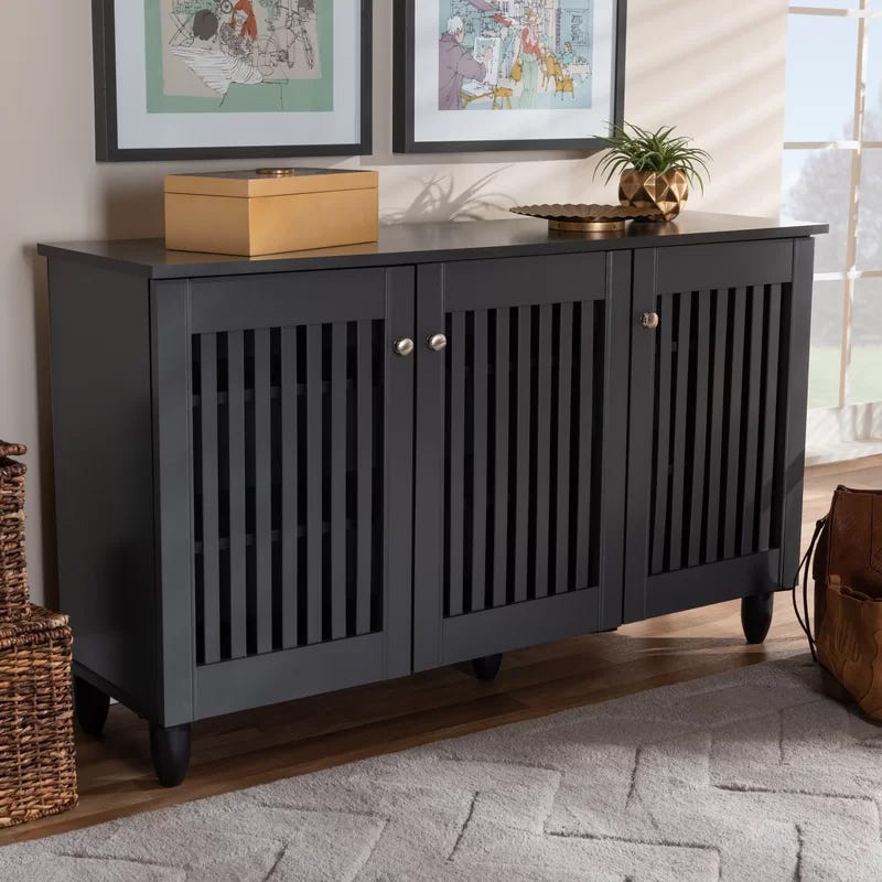 A dark gray wooden sideboard with slatted doors and round knobs, featuring a flat top for holding items.