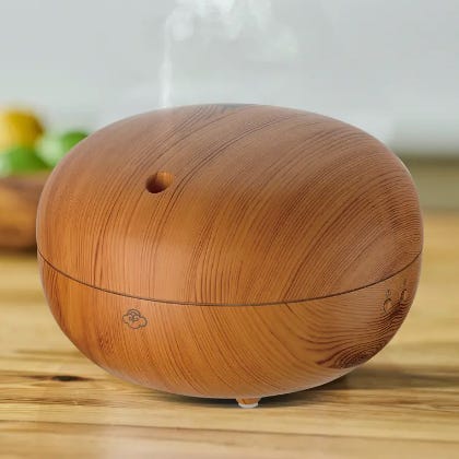 A wooden textured essential oil diffuser releasing steam.