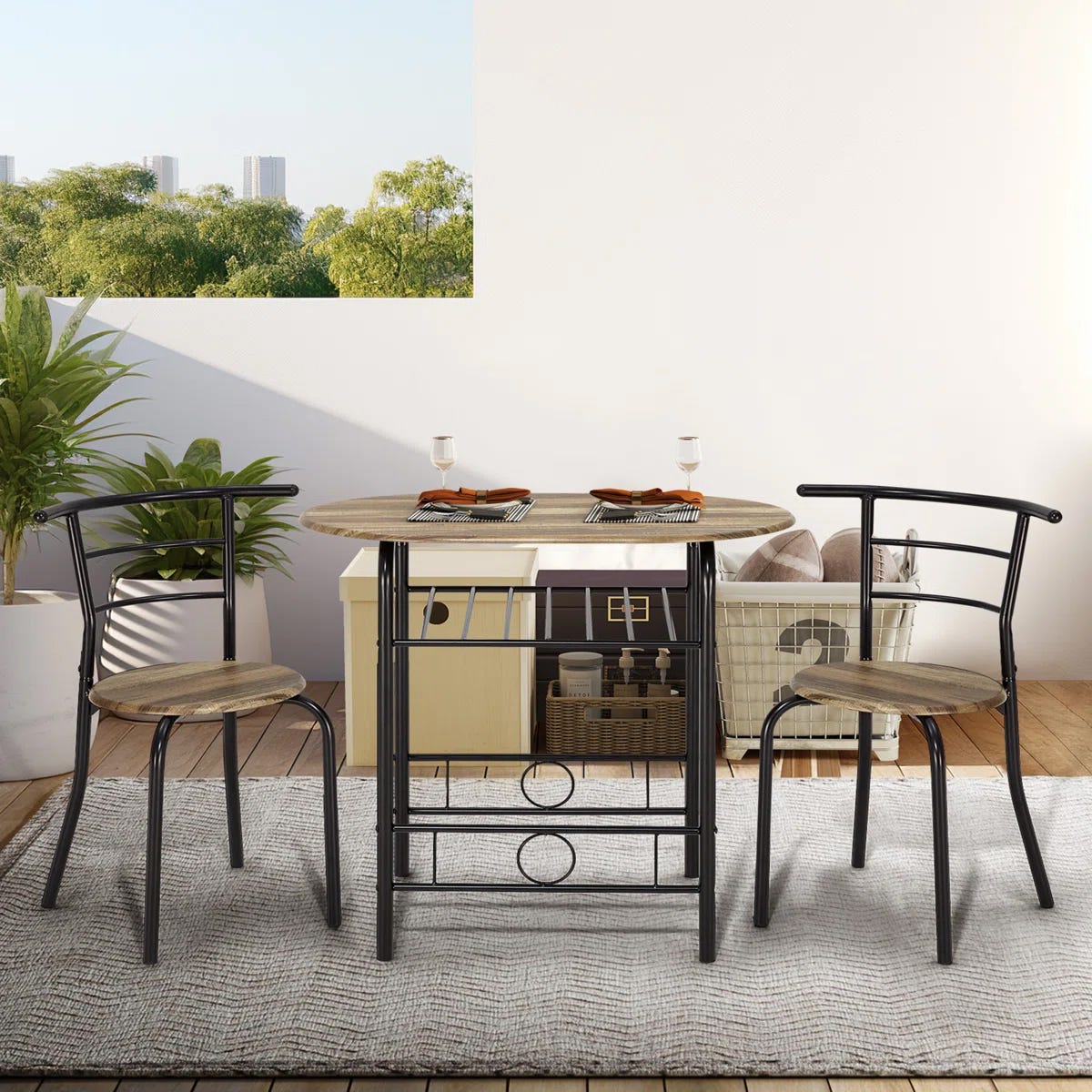 A compact dining set with a wooden round table, two metal-framed chairs with wooden seats, and two place settings with wine glasses, placed on a light gray rug.