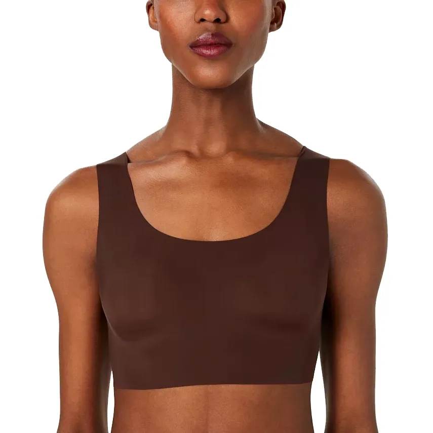 A woman is wearing a brown, seamless tank top.