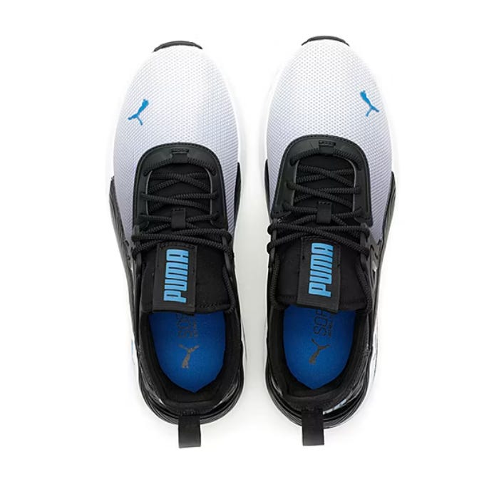 A pair of white and black PUMA sneakers with blue insoles viewed from above.