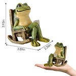 A solar-powered garden statue of a smiling frog sitting in a rocking chair, measuring 3.93 inches in height, 3.89 inches in width, and 2.36 inches in depth, is shown held in a hand for scale.