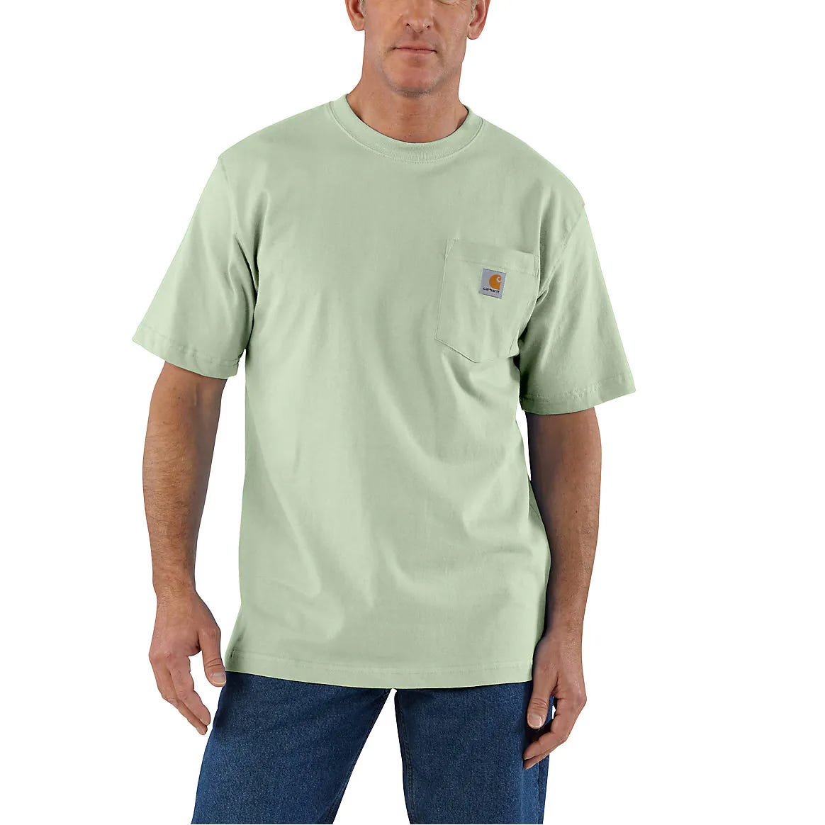 A man wearing a light green, pocketed T-shirt and blue jeans.