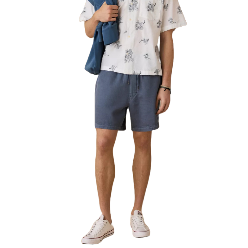 Blue knee-length shorts with a subtle drawstring waistband, offering a relaxed and casual style. Paired with a printed short-sleeve button-up shirt and white sneakers.