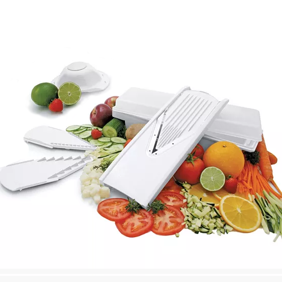 A white mandoline slicer alongside various sliced fruits and vegetables.