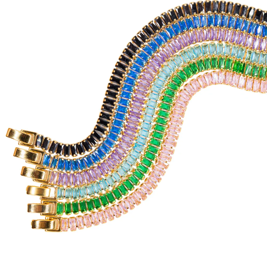 Five gold bracelets with colored gemstones in shades of black, blue, purple, teal, and green, arranged in a wavy pattern.