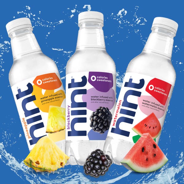 Three bottles of Hint flavored water with pineapple, blackberry, and watermelon infusions against a blue splash background.