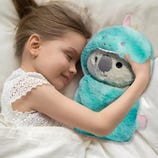 A young girl is peacefully sleeping while hugging a plush toy koala wearing a unicorn costume.