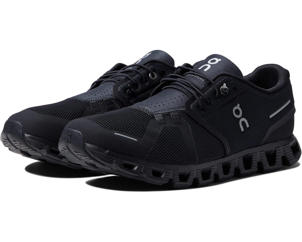 A pair of black running shoes with a distinctive sole design and white branding on the sides.