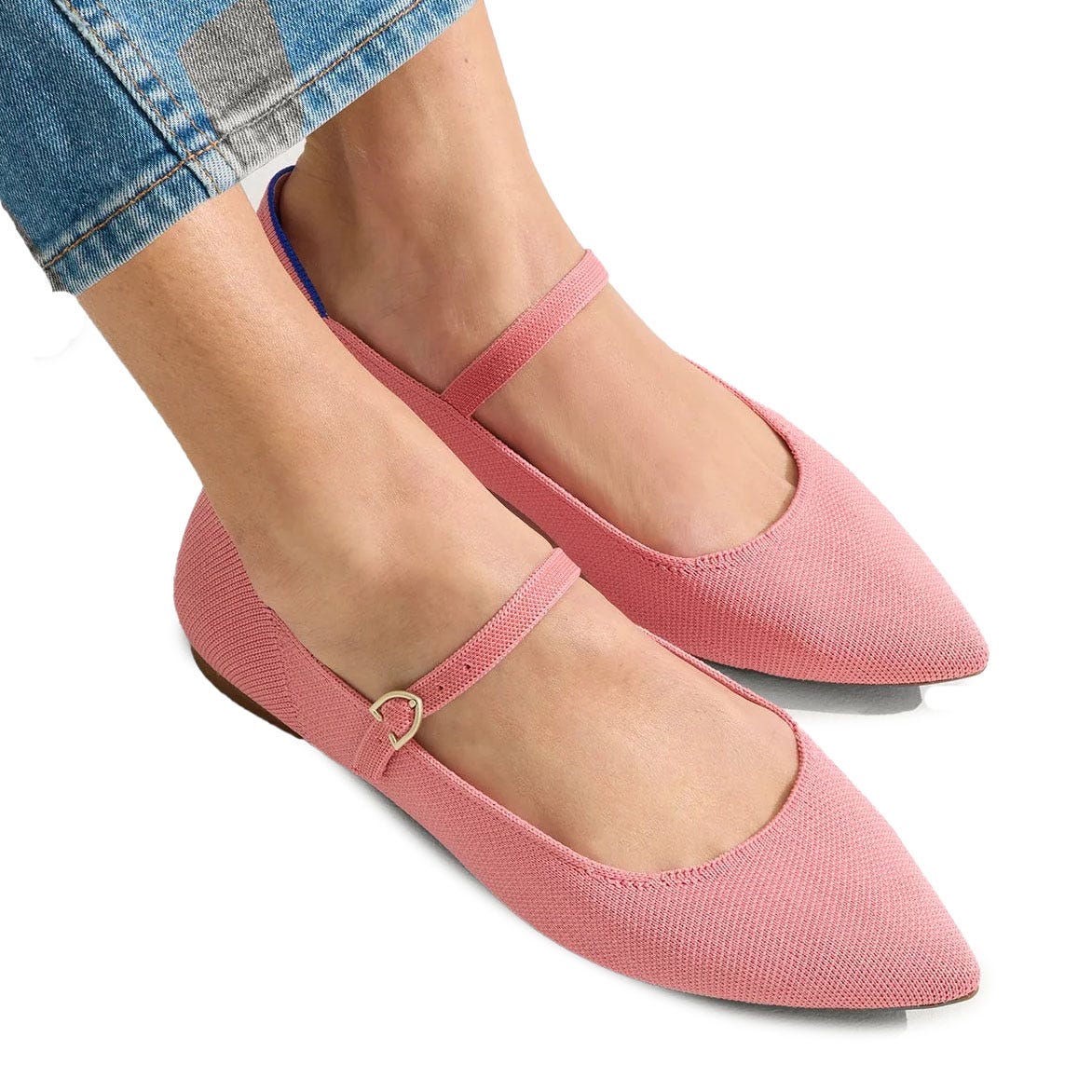 Pink pointed-toe Mary Jane flats from Rothy's with a textured fabric and a thin strap across the top, featuring a subtle gold buckle. They are paired with cropped jeans.