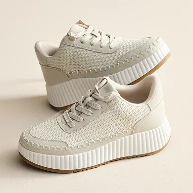 A pair of light beige, lace-up sneakers with a chunky platform sole and a textured knit upper.