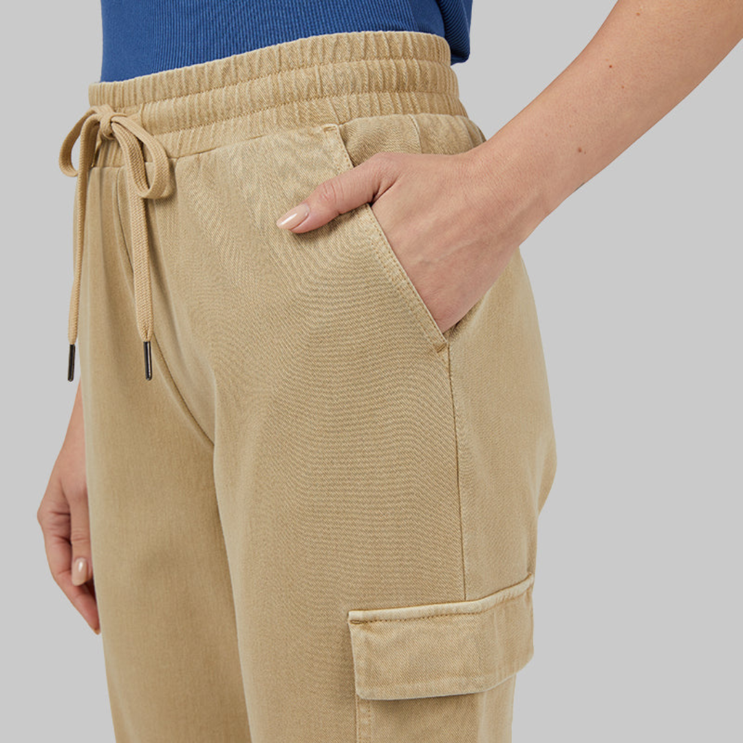 A person is wearing tan corduroy drawstring pants with a side pocket.