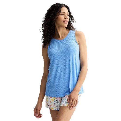 A woman models a blue ribbed tank top paired with floral-patterned shorts.