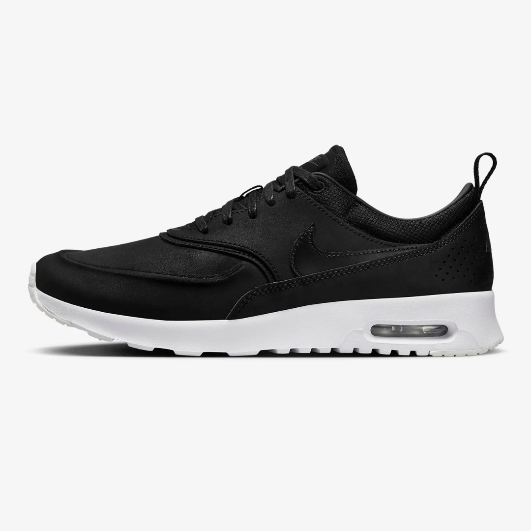 Black and white athletic sneaker with a visible air cushion in the heel.