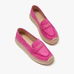 A pair of bright pink espadrille flats with a strap over the vamp.