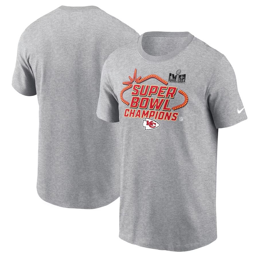 Gray Nike t-shirt featuring \“Super Bowl Champions\“ text, a Kansas City Chiefs logo, and Super Bowl LVII logos on the front.