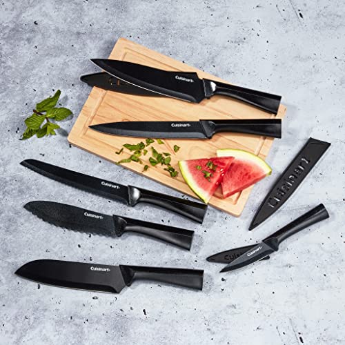 A collection of Cuisinart knives with black handles is displayed on a wooden cutting board alongside slices of watermelon; blade guards are included.