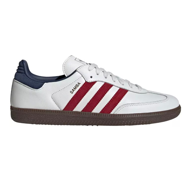 Adidas Samba shoes featuring a white leather upper with red stripes, dark blue heel, and a brown rubber sole. The word \“Samba\“ is printed on the side.