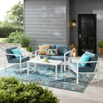 Outdoor furniture set with a sofa, two chairs, a coffee table, and an accent table on a patterned rug.