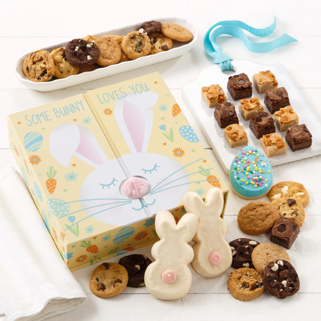 The Mrs. Fields Easter Variety Box features a decorated box with a bunny design and contains a selection of mini cookies, brownie bites, and iced cookies including bunny and egg shapes with colorful decorations.