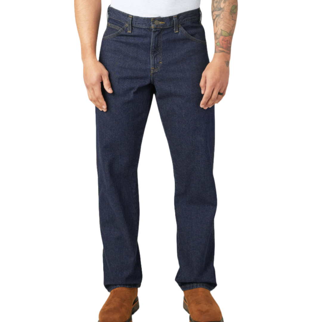 Dickies Regular Fit Jeans are dark blue denim with a classic straight-leg design, featuring traditional five-pocket styling and sturdy construction. The jeans are paired with brown boots and a white top in the image.