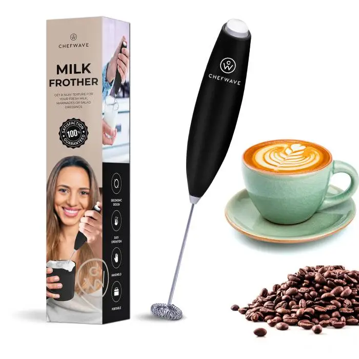 A handheld milk frother next to a packaged box, a cappuccino cup with creamy foam art, and coffee beans.