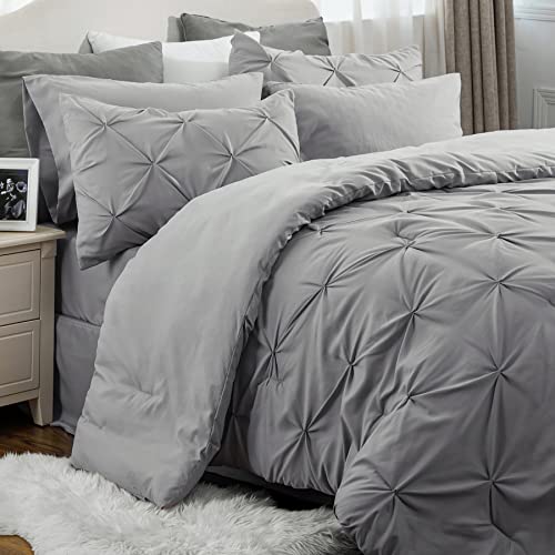 A gray quilted comforter set with a pin-tuck design, accompanied by matching pillow shams and decorative pillows.