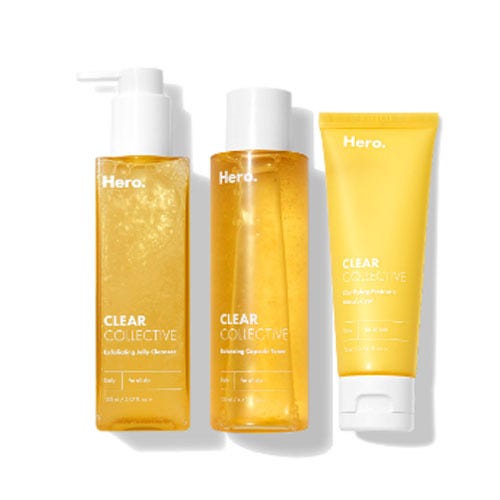 Three skincare products from Hero Cosmetics: a cleansing gel with a pump, a liquid exfoliator, and a yellow face mask tube.