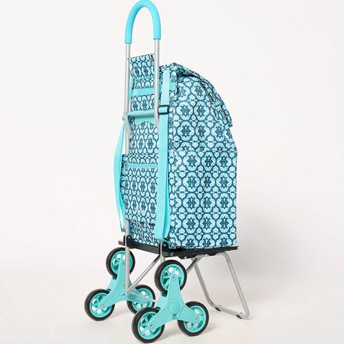 A turquoise and white patterned rolling shopping trolley with six wheels.