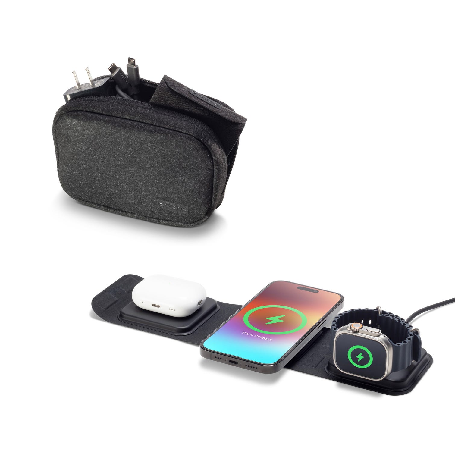 A phone, wireless earbuds, and a smartwatch are charging on a pad, alongside a travel case with charging cables.