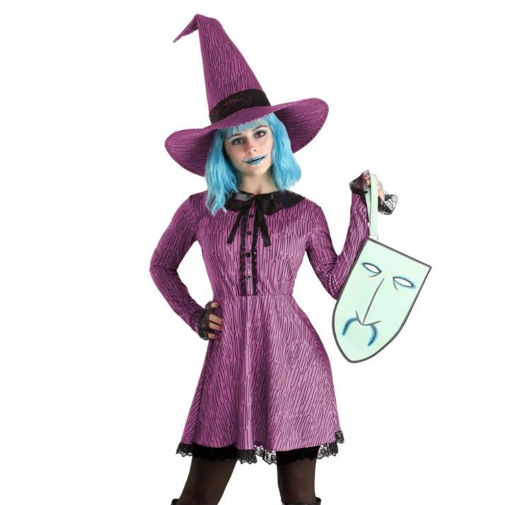 A person is dressed as a character with a purple witch hat, crinkled purple dress, blue wig, and a matching theatrical sad face mask held in one hand.