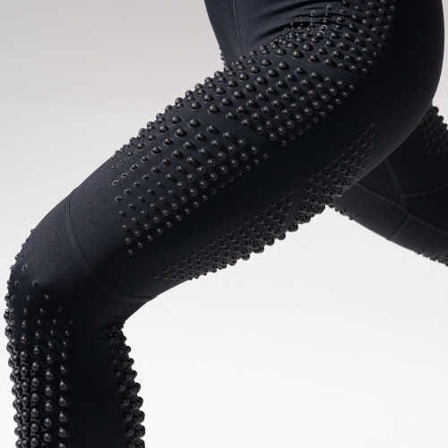 Black leggings with a unique design featuring numerous small, raised, spherical weights distributed across the material.