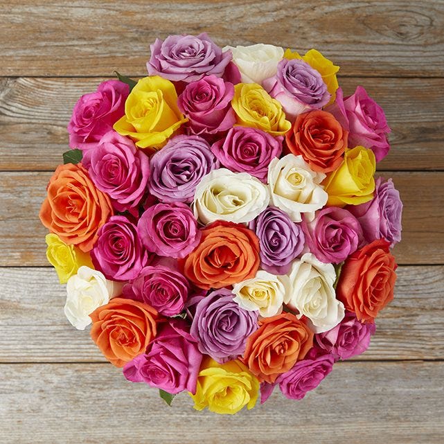 An arrangement of multicolored roses in shades of yellow, orange, pink, purple, and white.