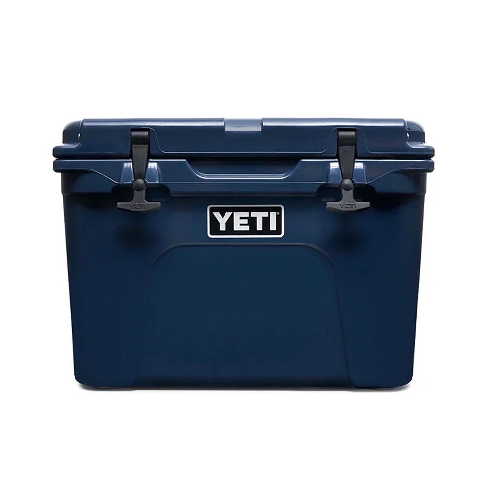 A blue YETI brand cooler with a closed lid and side handles.