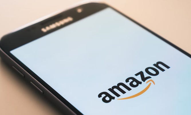 an image of a cell phone displaying the amazon app on a beige background