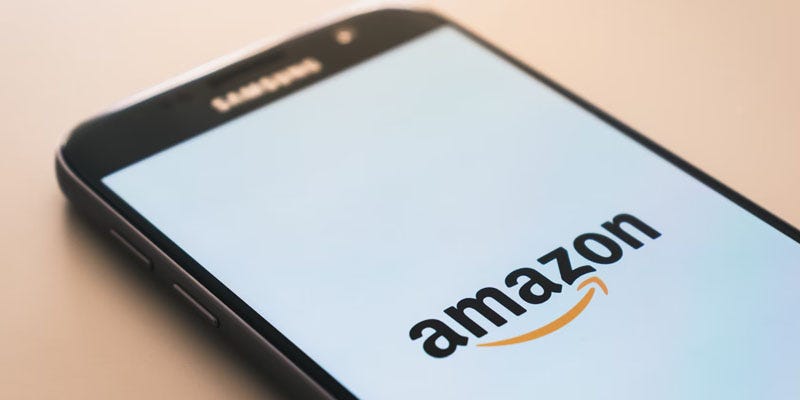 an image of a cell phone displaying the amazon app on a beige background