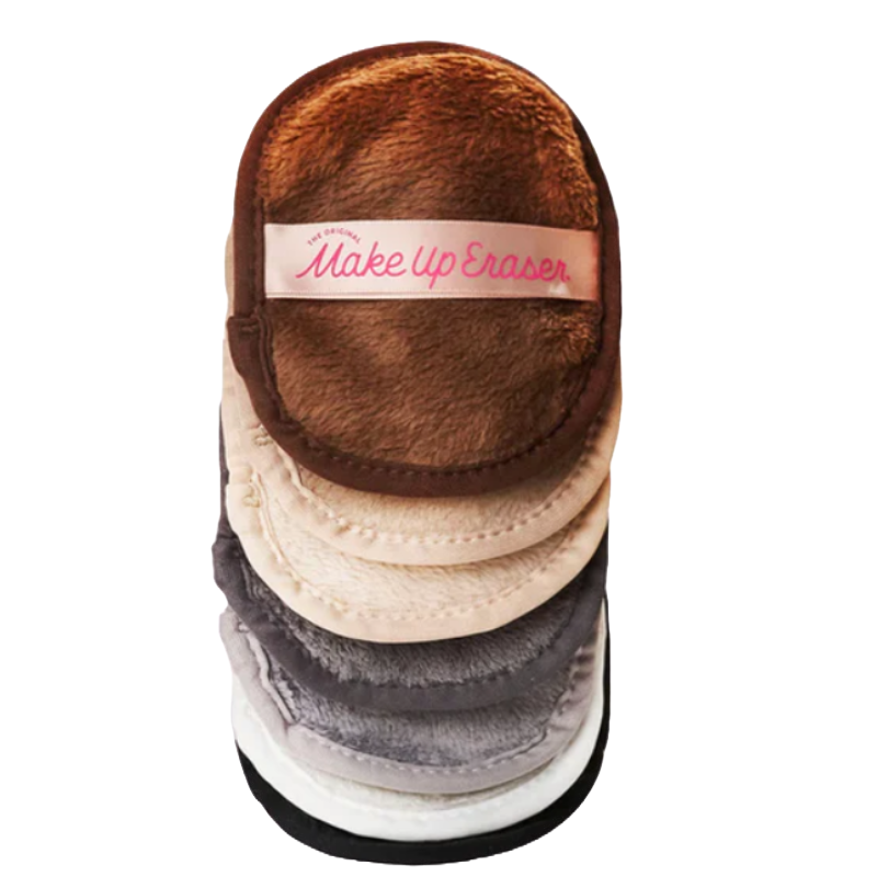 Seven reusable, neutral-toned makeup remover pads stacked. Each pad features a soft, fluffy texture with a band labeled \“Make Up Eraser.\“