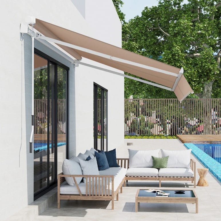 A retractable awning extended over a patio with outdoor furniture near a pool.