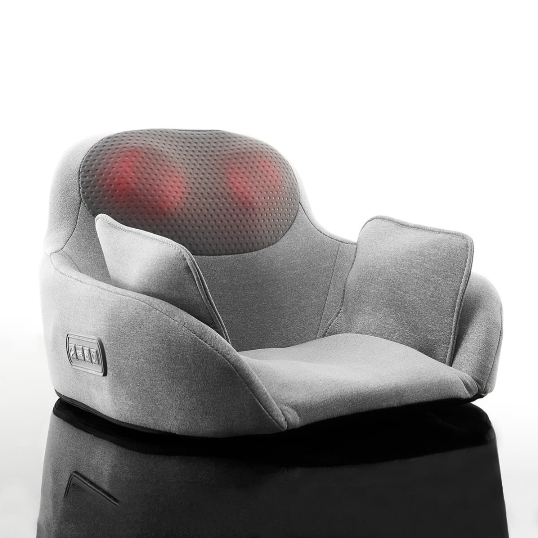 A gray heated massage chair with a curved design, featuring a textured backrest that emits light, indicating heating elements. It has side control buttons for adjustments and armrests for added comfort.