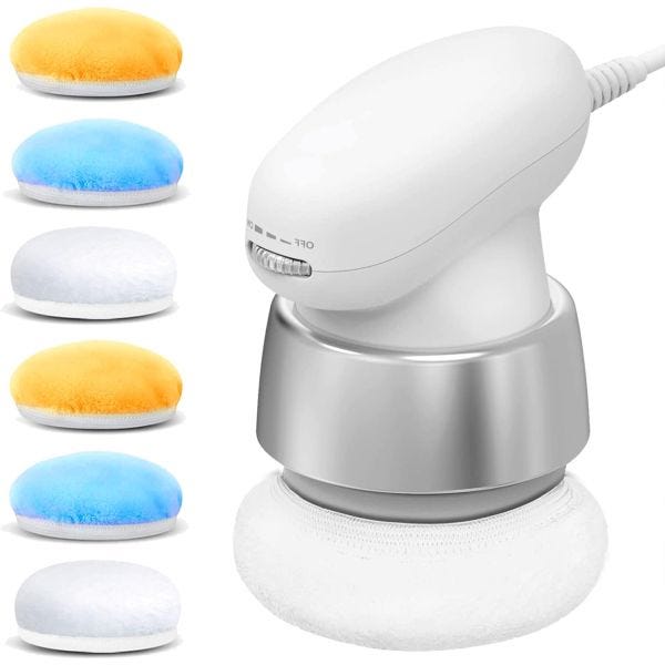 A handheld electrical cellulite massager with a white and silver design, equipped with interchangeable pads in orange, blue, and white. The pads are soft and fluffy, designed for different massage intensities.