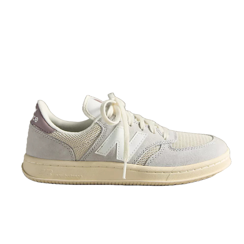 Cream-colored New Balance sneaker with a suede and mesh upper, white laces, and a light tan sole.